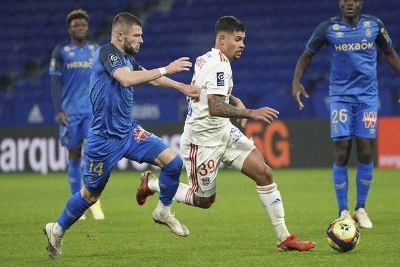 Reims&#039; Valon Berisha, left, and Lyon&#039;s Bruno Guimaraes fight for the ball during the French League One soccer match between Lyon and Reims, at the Groupama stadium in Lyon, France, Wednesday ...