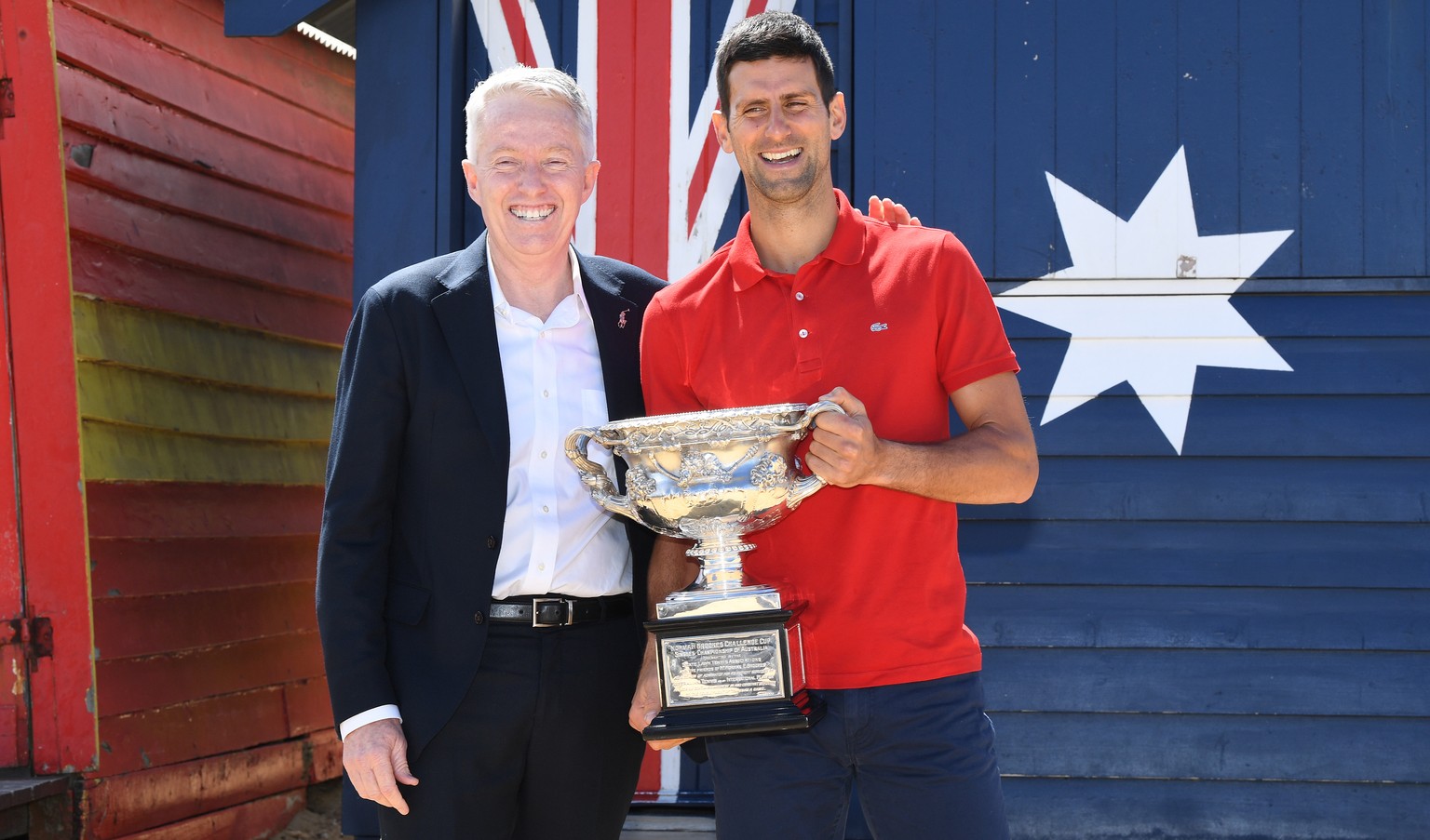 epa09028955 Novak Djokovic (R) of Serbia poses for photographs with Australian Open Tournament Director Craig Tiley (L) on Brighton Beach with the Norman Brookes Challenge Cup following his men&#039;s ...