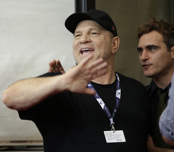 Film mogul Harvey Weinstein gestures to photographers, left, as actor Joaquin Phoenix speaks to him after the photo call for the film &#039;The Master&#039; at the 69th edition of the Venice Film Fest ...