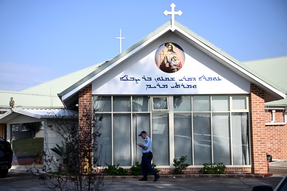 epa11281162 A NSW Police officer walks in front of Christ The Good Shepherd Church in the suburb of Wakeley, in Sydney, Australia, 16 April 2024. A 15-year-old boy has been arrested after a stabbing a ...