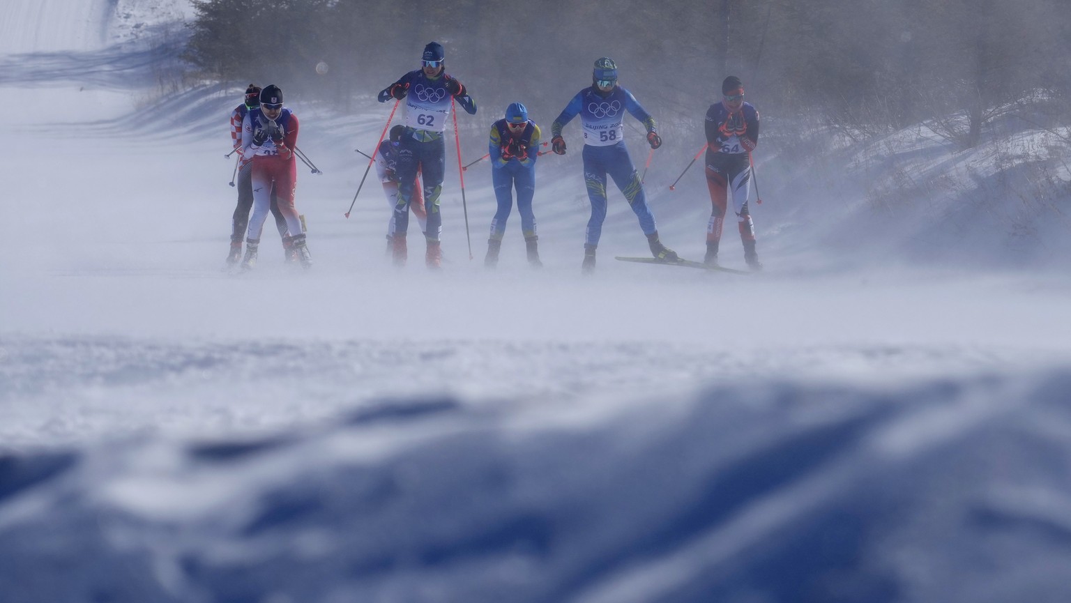 Wind blows snow as skiers compete during the women&#039;s 30km mass start free cross-country skiing competition at the 2022 Winter Olympics, Sunday, Feb. 20, 2022, in Zhangjiakou, China. (AP Photo/Ale ...