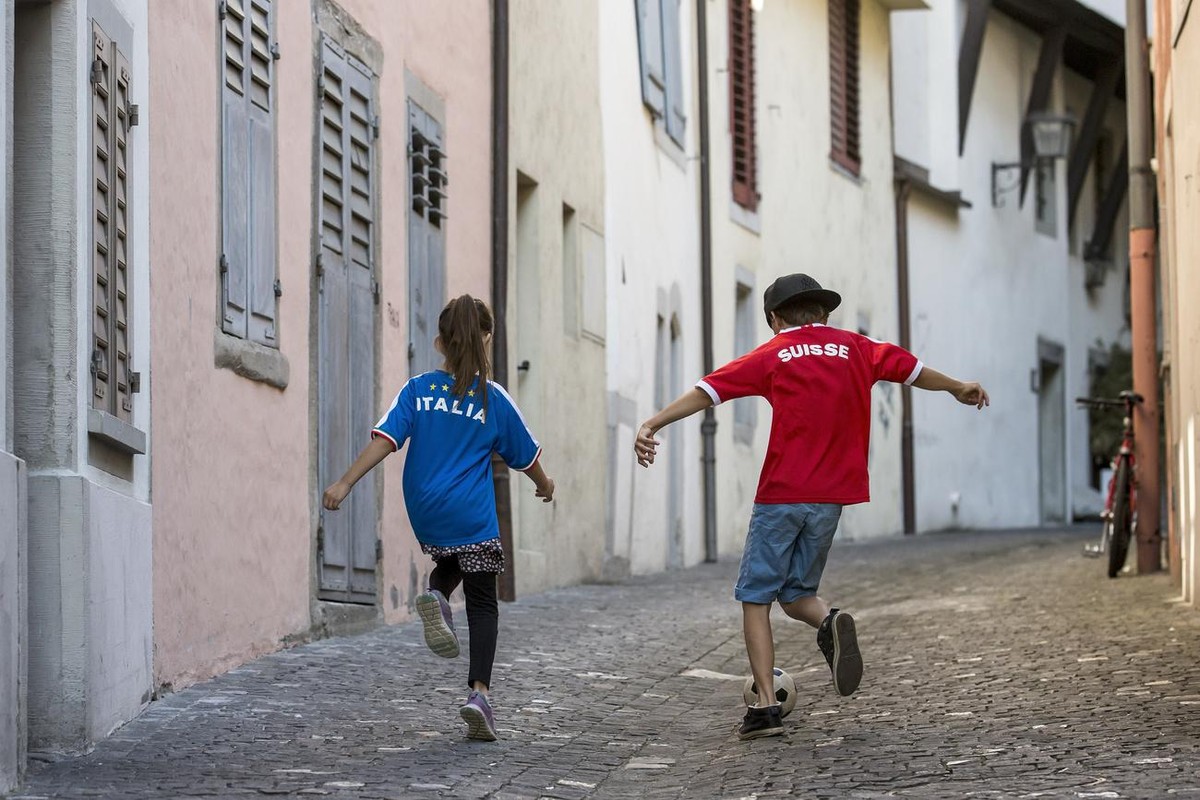 Das Fussballfieber ist nun auch in der Schweiz angekommen: Zwei Kinder mit einem italienischen und einem Schweizer Fussballtrikot spielen am Freitag, 3. Juni 2016, in den Gassen der Altstadt in Zug Fu ...