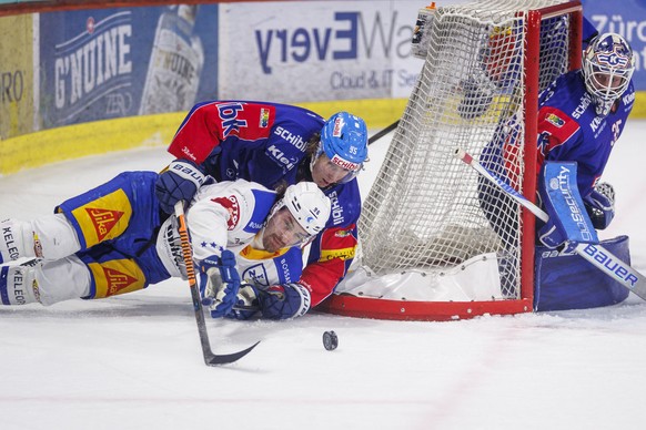 EV Zug Stuermer Daniel Vozenilek (#96) gegen EHC Kloten Verteidiger Nicholas Steiner (#95) und Torhueter Ludovic Waeber waehrend dem Qualifikationsspiel der Eishockey-Meisterschaft der National League ...