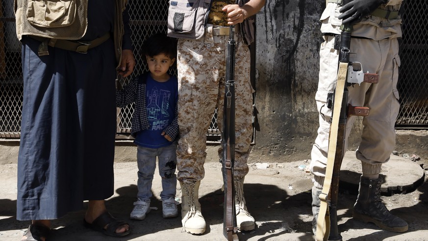 epa10537204 A Yemeni child stands among armed Houthi fighters during a rally to mobilize more fighters, in Sana'a, Yemen, March 22, 2023. Houthi fighters have launched an offensive against Y...