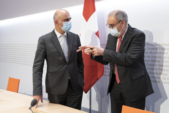 Bundesrat Alain Berset, links, diskutiert Bundespraesident Guy Parmelin am Ende einer Medienkonferenz des Bundesrates zur aktuellen Situation im Zusammenhang mit dem Coronavirus, am Dienstag, 30. Nove ...