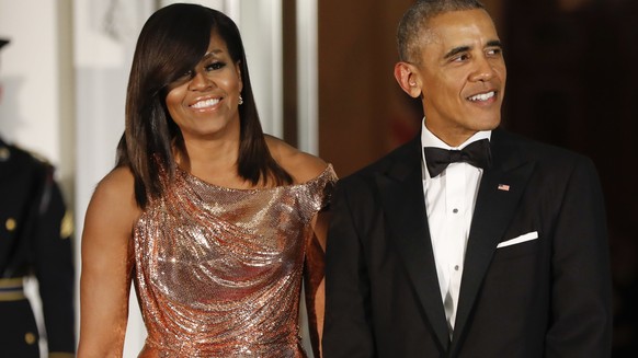 FILE - In this Oct. 8, 2016 file photo, President Barack Obama and first lady Michelle Obama wait to greet Italian Prime Minister Matteo Renzi and his wife Agnese Landini for a State Dinner at the White House in Washington. Netflix says that it has reached a deal with Barack and Michelle Obama to produce material for the streaming service. Netflix said Monday, May 21, 2018, in a tweet, that the former president and first lady will produce films and series for the service, potentially including scripted and unscripted series, documentaries and features. (AP Photo/Pablo Martinez Monsivais, File)
