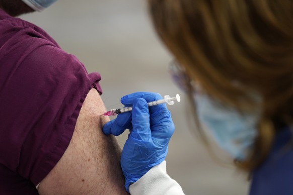 FILE - In this Tuesday, Jan. 5, 2021, file photo, a healthcare worker receives a second Pfizer-BioNTech COVID-19 vaccine shot at Beaumont Health in Southfield, Mich. New research suggests that Pfizer ...