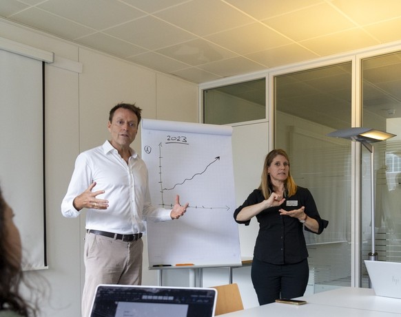 Roman Probst, CEO von Procom (Mitte) wird an einer Sitzung von einer Dolmetscherin in Gebärdensprache übersetzt.