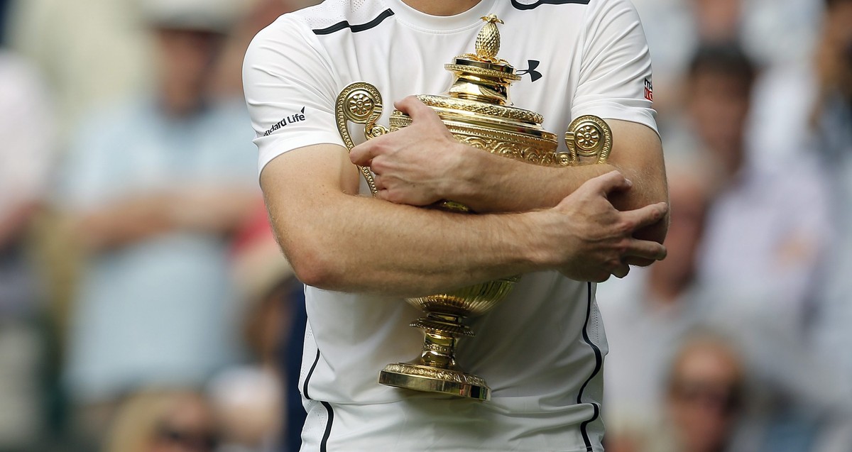 epa05418843 Andy Murray of Britain with the championship trophy following his win over Milos Raonic of Canada in the men's singles final of the Wimbledon Championships at the All England Lawn Ten ...