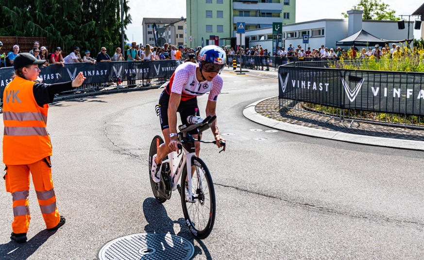 Die Schweizer Triathletin Daniela Ryf ist mit dem Rennrad fertig, es geht in Richtung Wechselzone. Eine verkehrskadettin weisst der mehrfach Ironman Siegerin den Weg. (Rapperswil-Jona, Schweiz, 11.06. ...