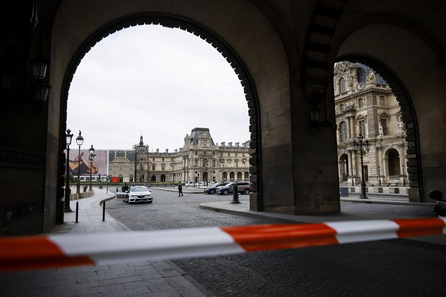 Police officers stand guard outside the Louvre Museum as people are evacuated after it received a written threat, in Paris, Saturday Oct. 14, 2023. The Louvre Museum says it is closing for the day and ...