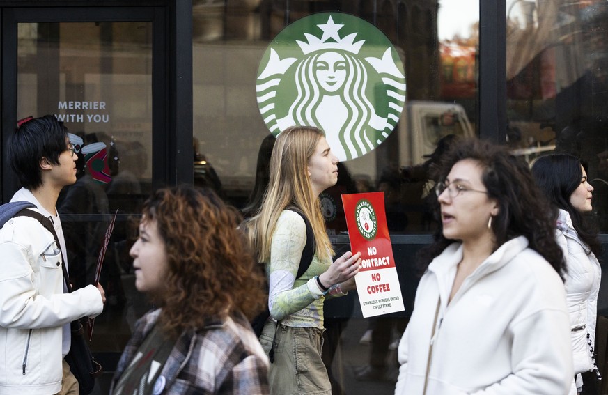 epa10978861 People participate in a picket line as part of a nationwide protest organized in response to a lack of a contract for workers, outside of a Starbucks store in New York, New York, USA, 16 N ...