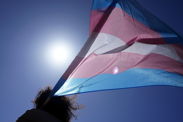 An attendee carries a Transgender flag during a march to celebrate International Transgender Day of Visibility, in Lisbon, Portugal, Sunday, March 31, 2024. (AP Photo/Armando Franca)