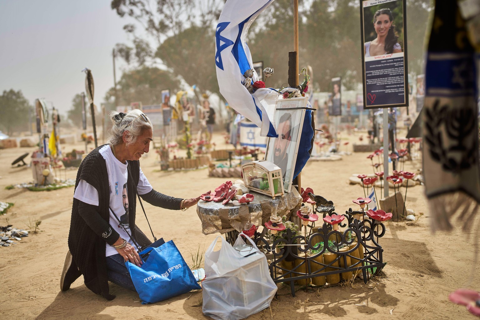Jenia Abasov, mother of, kneels in front of an altar to his son at the site of Oct. 7, 2023 attack by Hamas militants at the Nova music festival, near Kibbutz Reim, southern Israel, during the Israel& ...