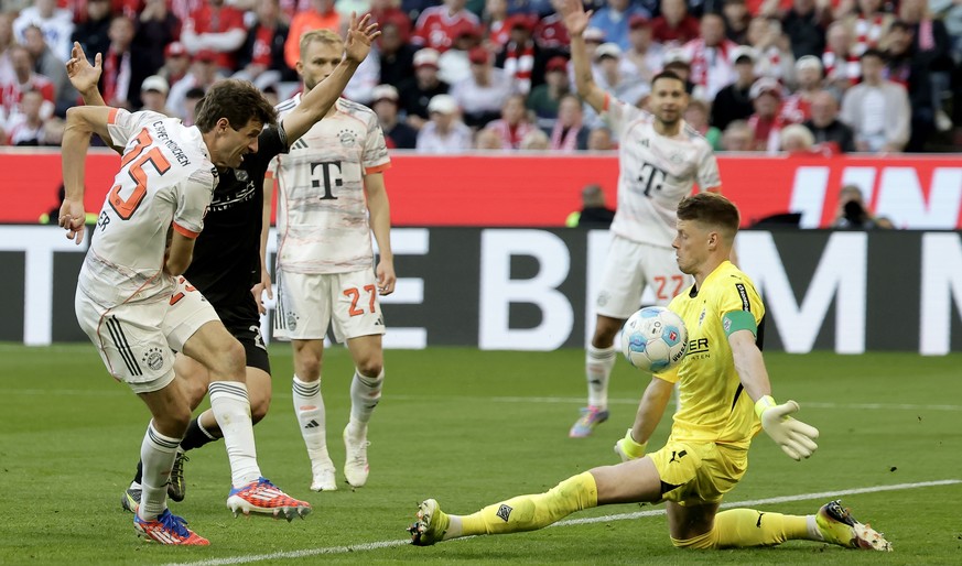 epa12089464 Thomas Mueller of Bayern Munich (L) and goalkeeper Jonas Omlin of Moenchengladbach (R) in action during the German Bundesliga soccer match between FC Bayern Munich and Borussia Moenchengla ...