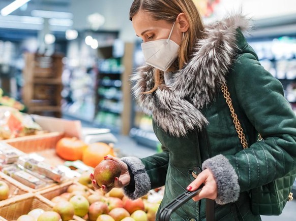 Frau mit FFP2-Maske kauft ein.