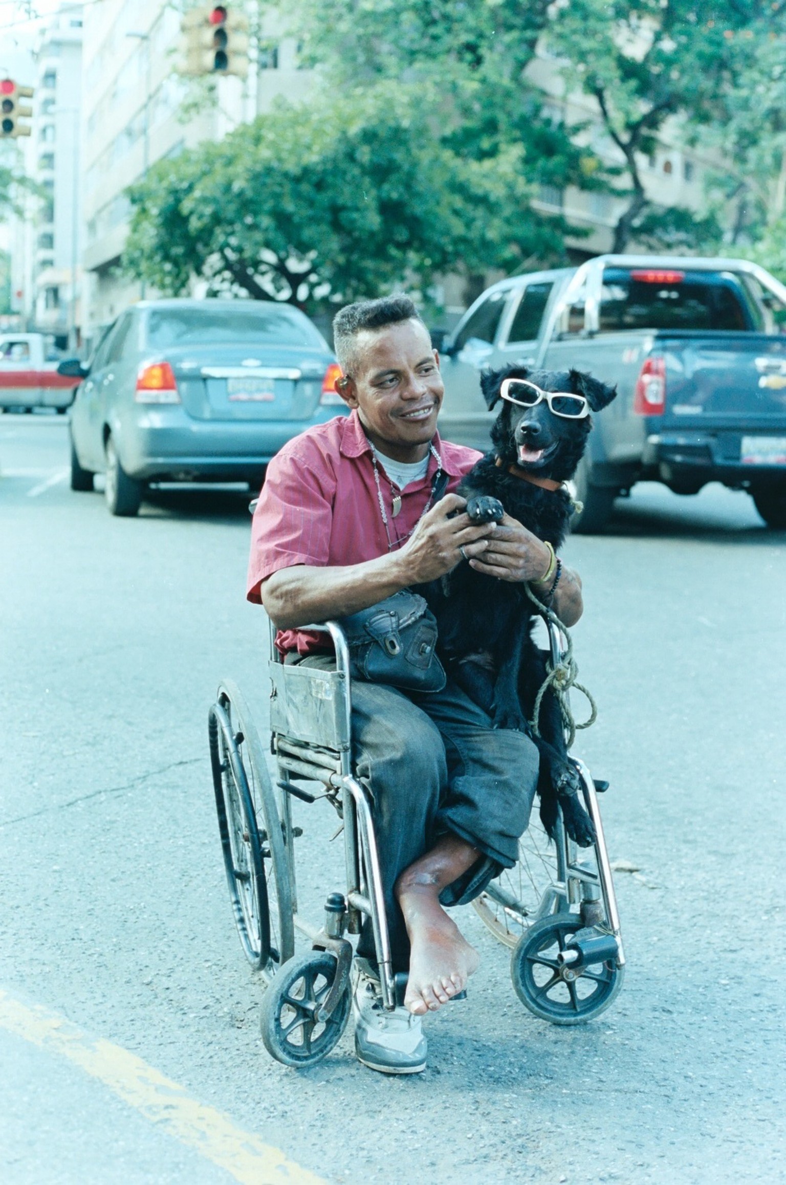 Ein gehbehinderter Mann spielt mit seinem Hund in den Strassen von Caracas.&nbsp;