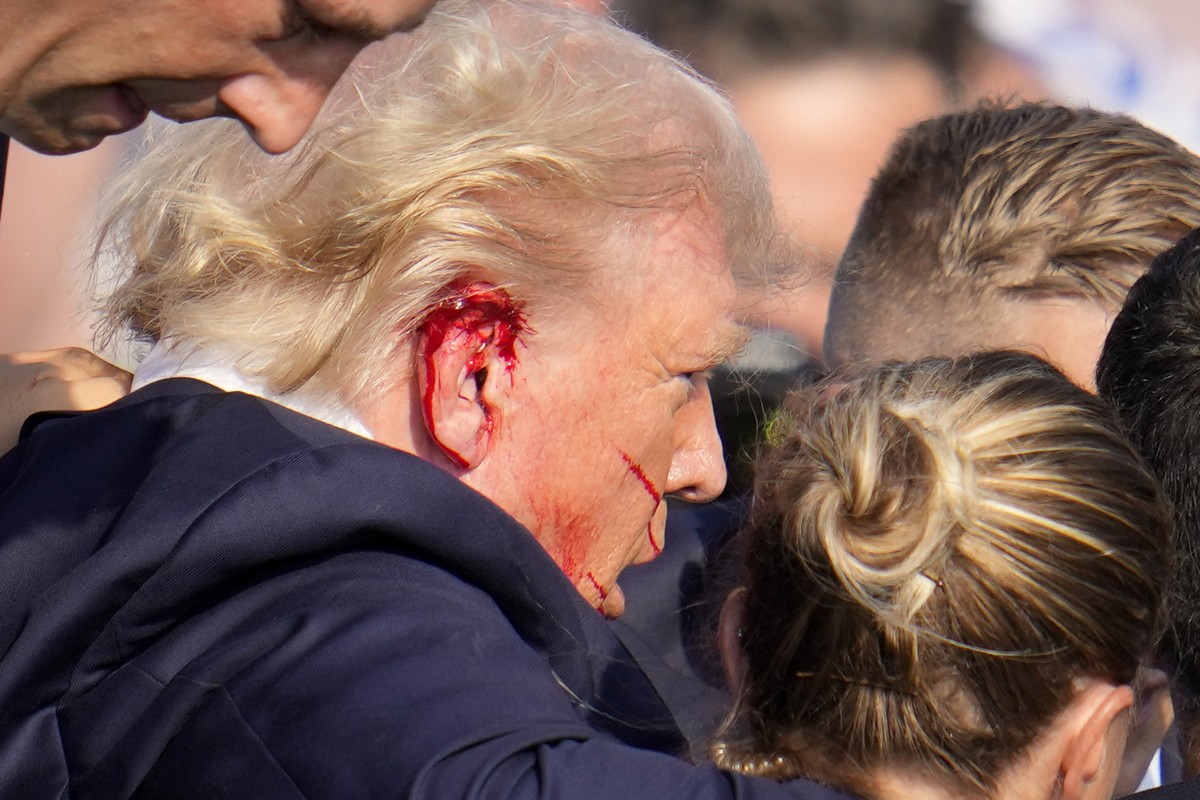 Republican presidential candidate former President Donald Trump is escorted to a motorcade following an attempted assassination at a campaign event in Butler, Pa., on Saturday, July 13, 2024. (AP Phot ...