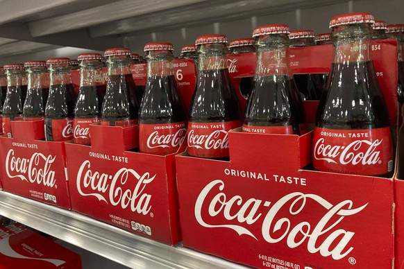 Bottles of Coca-Cola are stacked on a shelf in a grocery store, Wednesday, Dec. 15, 2021, in Surfside, Fla. Coca-Cola���s revenue rose 10% to $9.5 billion in the fourth quarter, Thursday, Feb. 10, 202 ...