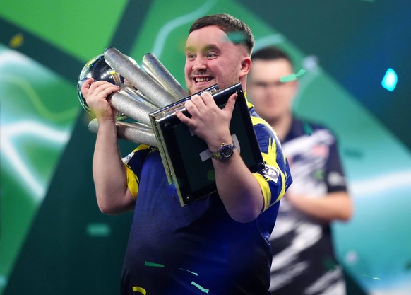 Luke Littler celebrates with the Sid Waddell trophy after victory against Gian van Veen after the final of the Paddy Power World Darts Championship at the Alexandra Palace in London, Saturday, Jan. 3, ...