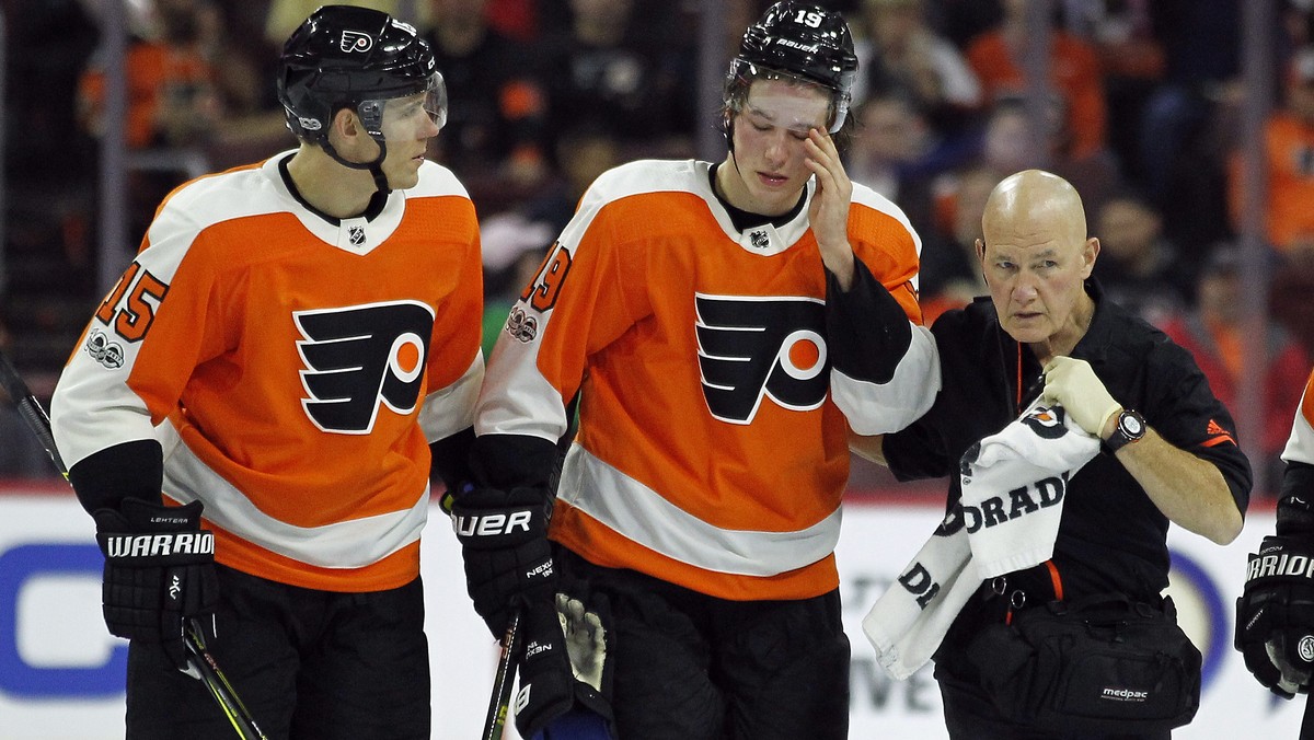 CORRECTS TO SAY PATRICK DID NOT RETURN TO THE GAME AFTER THE INJURY - Philadelphia Flyers' Nolan Patrick, center, is helped of the ice by Jori Lehtera, left and a member of the training staff aft ...
