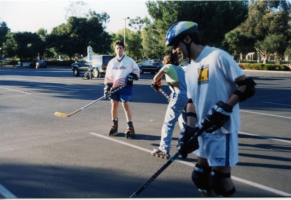 Page und Brin spielen mit anderen Mitarbeitern Hockey auf dem Firmenparkplatz.