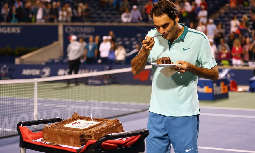 TORONTO, ON - AUGUST 08: Roger Federer of Switzerland has a piece of his birthday cake after a quarterfinals win against David Ferrer of Spain during Rogers Cup at Rexall Centre at York University on  ...