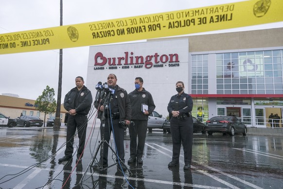 Los Angeles Police Department Public Information Officer Capt. Stacy Spell, second from left, speaks in a press conference at the scene where two people were struck by gunfire in a shooting at the Bur ...