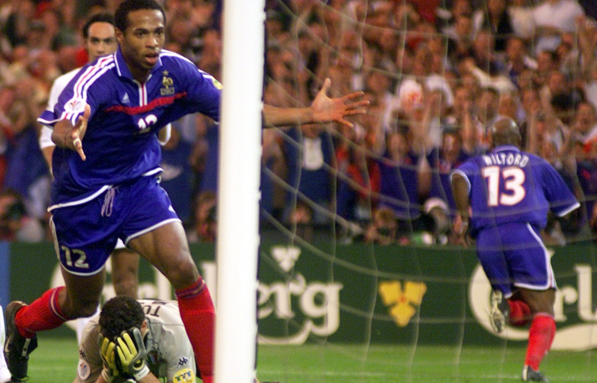 France's Thierry Henry celebrates Sylvain Wiltord's goal, right, as Italy's goalkeeper Francesco Toldo holds his head in his hands during the final of the EURO 2000 soccer championships ...