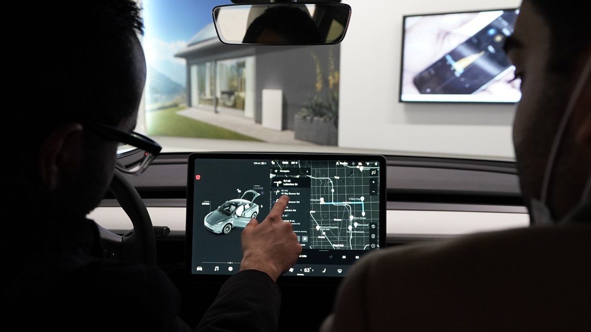 FILE - Customers look over a Tesla Model Y Long-range on display at the Tesla Gallery on Feb. 24, 2021, in Troy, Mich. The top U.S. transportation official says Tesla shouldn?t call its partially auto ...