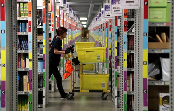 epa06355814 A worker at the Amazon logistics and distribution center in Rheinberg, Germany, 28 November 2017. The Amazon logistics center is directly connected to a &#039;Deutsche Post&#039; DHL shipp ...