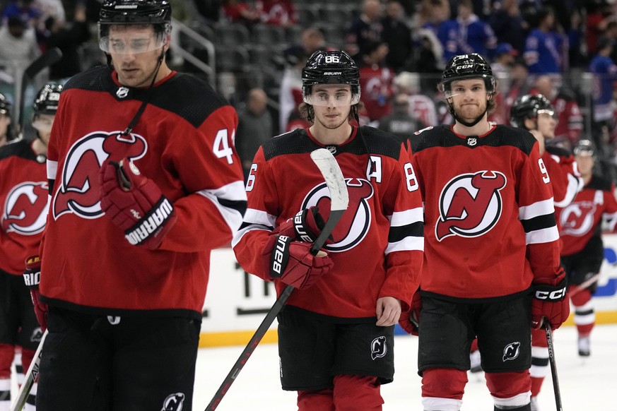 New Jersey Devils players, including Jack Hughes, center, leave the rink after Game 1 of an NHL hockey Stanley Cup first-round playoff series against the New York Rangers in Newark, N.J., Tuesday, Apr ...