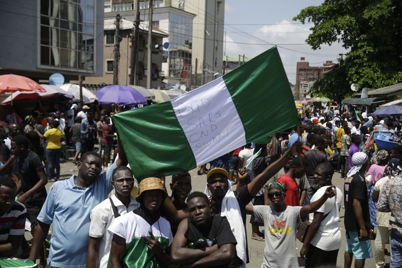 People hold banners as they demonstrate on the street to protest against police brutality, in Lagos, Nigeria, Tuesday Oct. 20, 2020. After 13 days of protests against police brutality, authorities hav ...