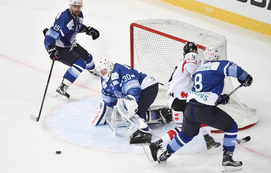 Minsk&#039;s Nikita Komarov, goalkeeper Ben Scrivens, and Ilya Shinkevich, from left, fight for the puck with Team Canada&#039;s Andrew Ebbet, second from right, during the game between Dinamo Minsk a ...