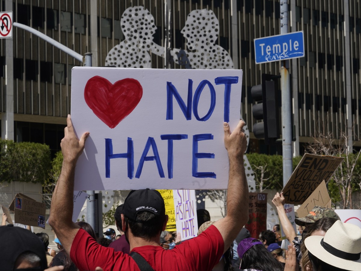 Demonstrators rally past the silhouette art piece named "Molecule Man" in front of the Edward Roybal Federal Building, at a rally against Asian hate crimes, Saturday, March 27, 2021 downtown ...