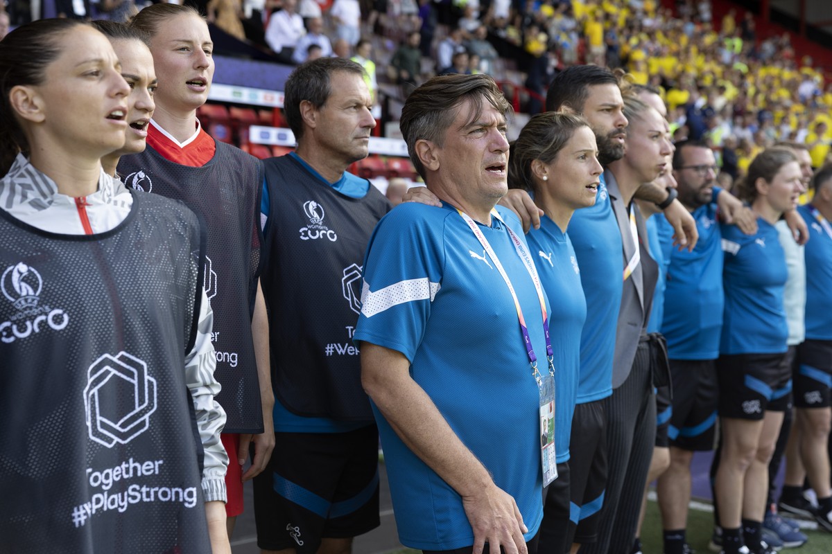Switzerland's head coach Nils Nielsen, 5th left, sings the Swiss national anthem with Switzerland's substitutes players and staff, prior the UEFA Women's England 2022 group C preliminar ...