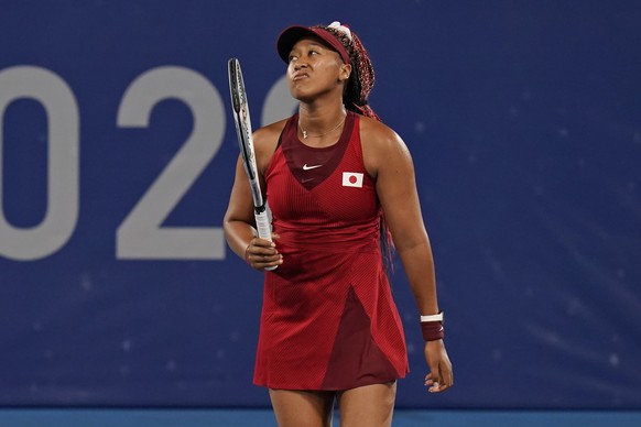 Naomi Osaka, of Japan, reacts after losing a point to Marketa Vondrousova, of the Czech Republic, during the third round of the tennis competition at the 2020 Summer Olympics, Tuesday, July 27, 2021,  ...