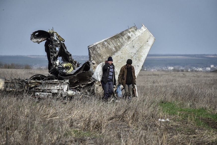 epa10564726 Local residents collect scrap metal from a crashed fighter jet in the Kharkiv region, Ukraine, 08 April 2023. Russian troops entered Ukrainian territory on 24 February 2022, starting a con ...