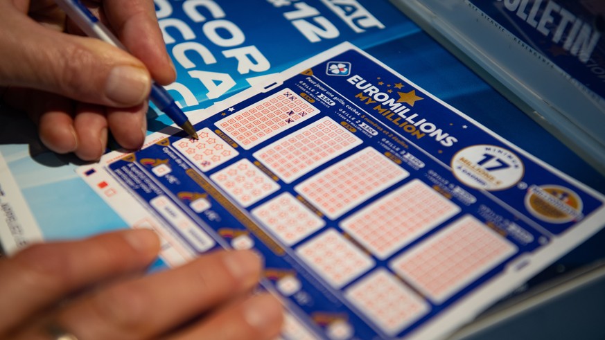 epa08862326 A person plays a EuroMillions grid in Bordeaux, France, 04 December 2020. The jackpot for this draw will reach 200 million euro. Before 2020, the jackpot was capped at 190 million euros. E ...