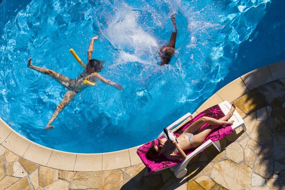 epa06917829 People enjoy the warm and sunny weather by a swimming pool in Lavigny, Switzerland, 29 July 2018. Switzerland continues to suffer the effects of one of the warmest Julys on record. EPA/VAL ...