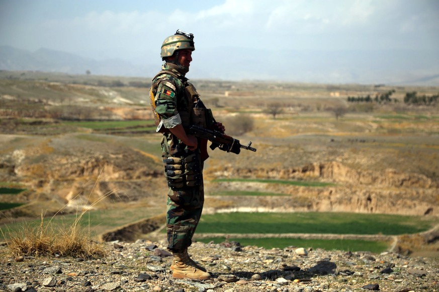 epa09061635 Afghan security official stands guard at a checkpoint as part of an operation against suspected militants in Sherzad district of Nangarhar province, Afghanistan, 08 March 2021. Security fo ...