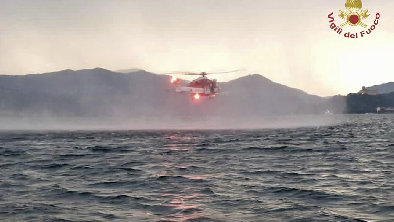 In this image released by the Italian firefighters a helicopter search for missing after a tourist boat capsized in a storm on Italy&#039;s Lago Maggiore in the northern Lombardy region, Sunday, May 2 ...