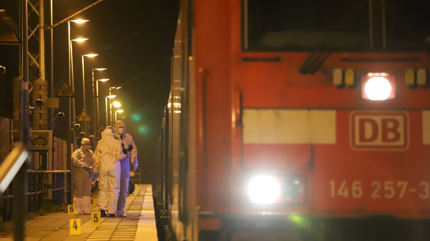 epa10429459 Crime scene investigators work at the regional train in which a man attacked passengers with a knife stands at Brokstedt station in Brokstedt, northern Germany, 25 January 2023. According  ...