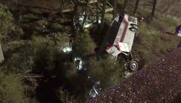 This photo provided by Jesus Tejada shows first responders searching around a bus that plunged into a ravine, Tuesday, March 13, 2018 on Interstate 10, Loxley, Ala. Several people were on board, and a ...