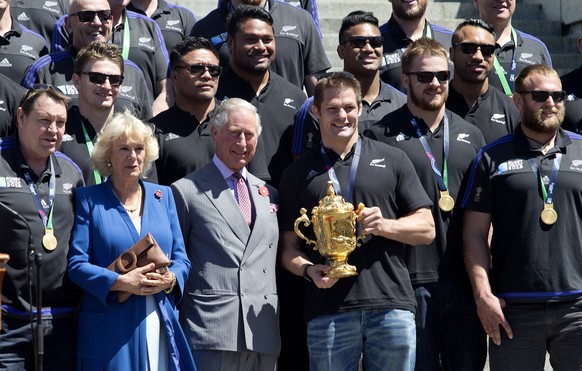 New Zealand rugby captain Richie McCaw holds the Webb Ellis trophy with Britain&#039;s Prince Charles and the Duchess of Cornwall during a welcome home parade for the All Blacks in Wellington, New Zea ...