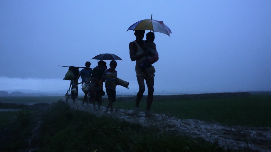epa06262721 YEARENDER 2017 SEPTEMBER 
Rohingya refugees walk under the rain as they arrive at Bangladesh border at Teknaf, Bangladesh, 09 September 2017. According to United Nations more than 270,000  ...