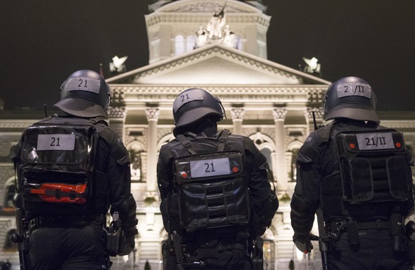 Polizisten beobachten das Bundeshaus und den Bundesplatz, am Samstag, 10. Oktober 2015 in Bern. Die Polizei bezieht Stellung vor einem angekuendigten aber nicht bewilligten Antifaschistischen Abendspa ...