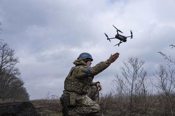 A Ukrainian serviceman of the 68 Oleksa Dovbush hunting brigade, launches a drone at the frontline near Vuhledar, Ukraine, Wednesday, Feb. 22, 2023. (AP Photo/Evgeniy Maloletka)