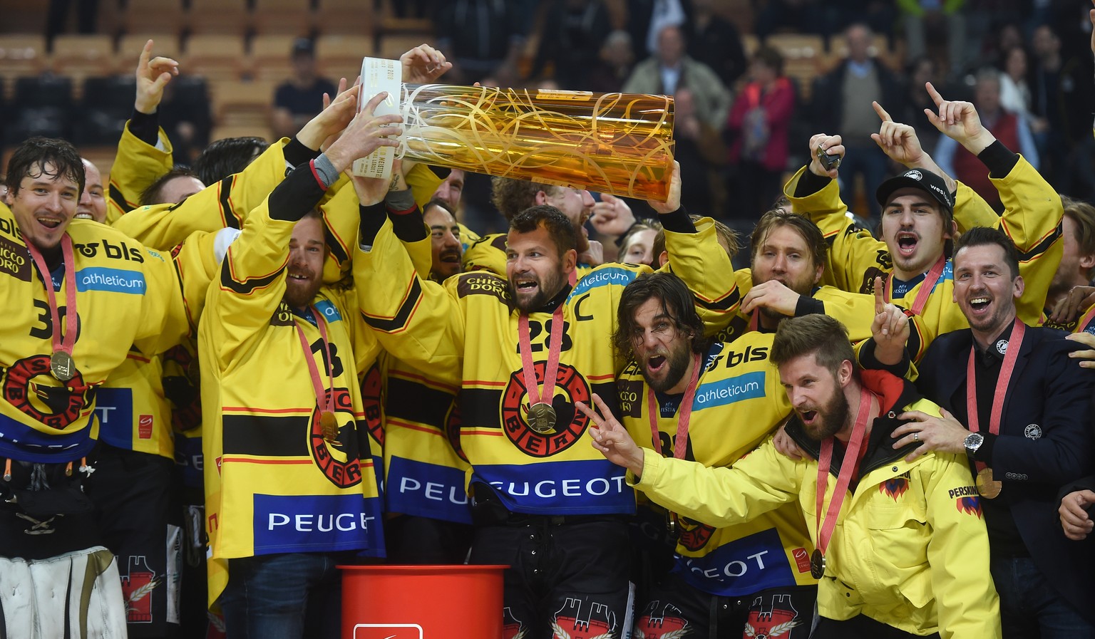 Berns Mannschaft feiert den Sieg zum Meistertitel und Captain Martin Pluess, Mitte, stemmt den Pokal in die Hoehe neben Trainer Lars Leuenberger, rechts aussen, nach dem fuenften Eishockey Playoff-Fin ...