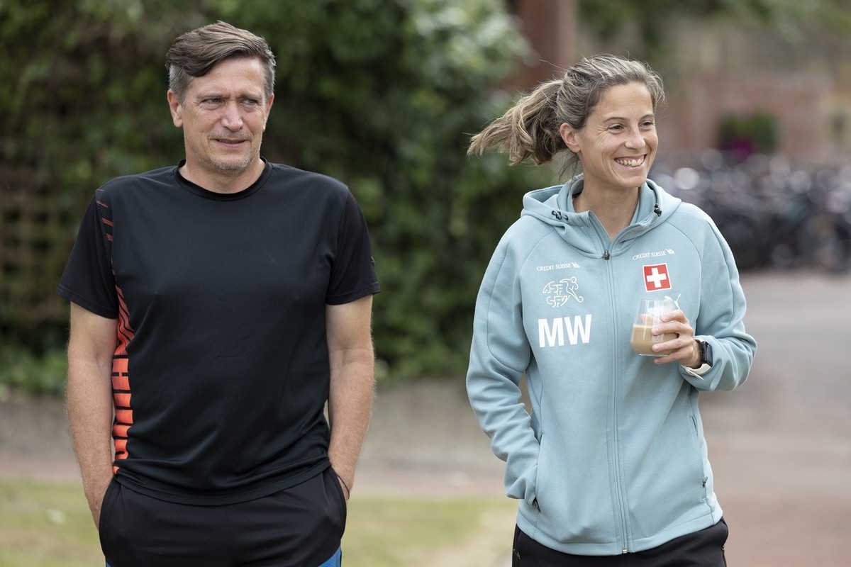 Switzerland's head coach Nils Nielsen, left, and Switzerland's assistant coach Marisa Wunderlin, right, walk in the garden of the hotel Oulton Hall, at the UEFA Women's Euro England 202 ...